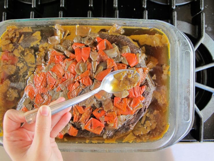 Spooning gelled fat out of roasting dish.
