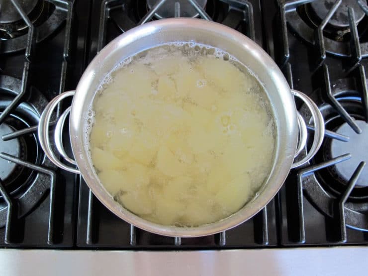 Peeled, diced potatoes in a stock pot of water.