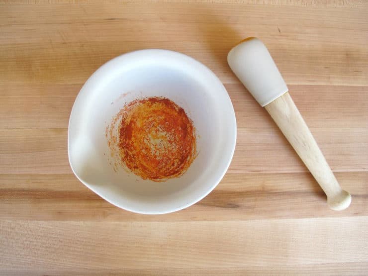 Ground saffron threads in a mortar and pestle.
