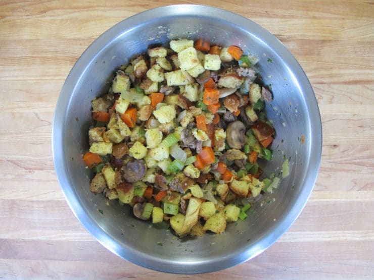 Challah cubes and sauteed vegetables tossed together in a large bowl.