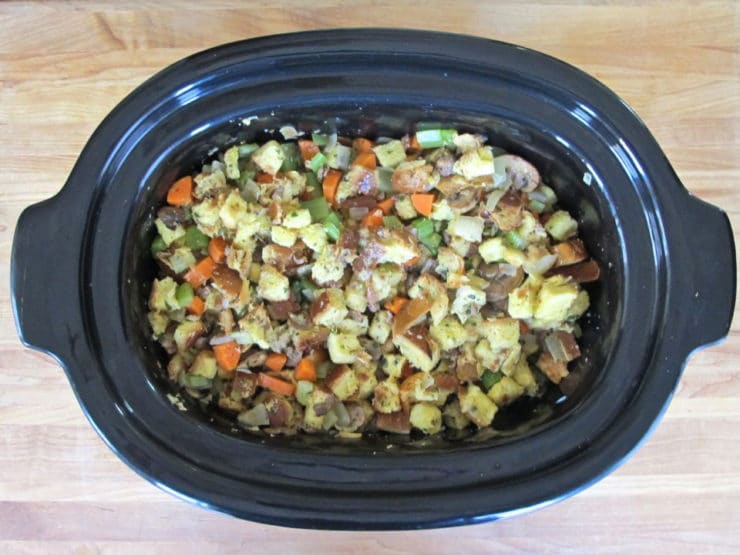 Challah stuffing pourerd into a greased slow cooker liner.