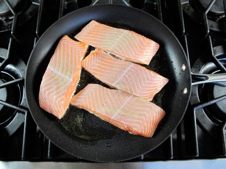 Salmon fillets in a skillet.