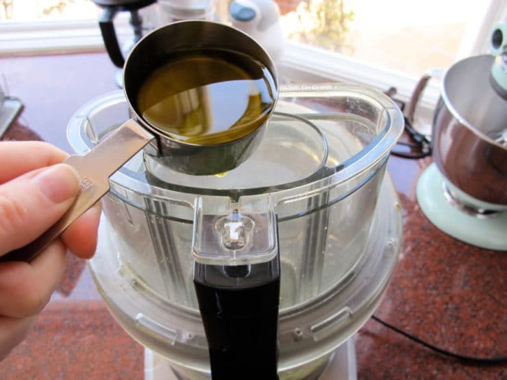 Drizzling oil into a running food processor.