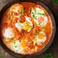 Horizontal shot of cast iron pan filled with Shakshuka.