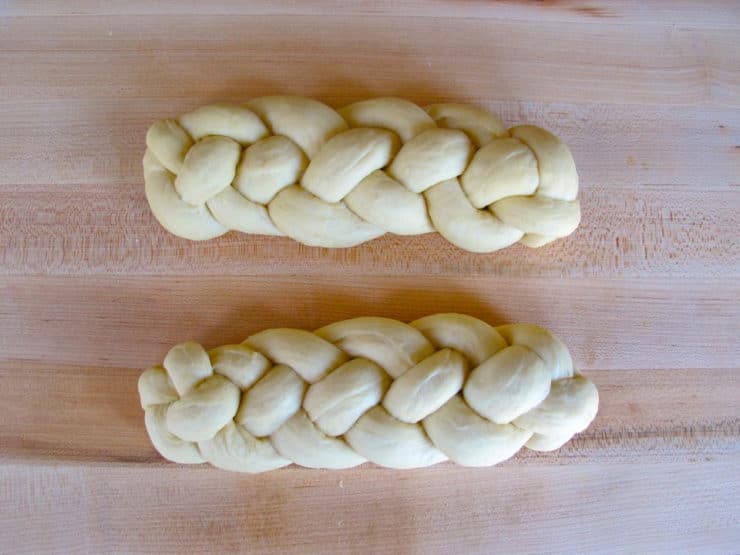 Braided challah loaves on a board.