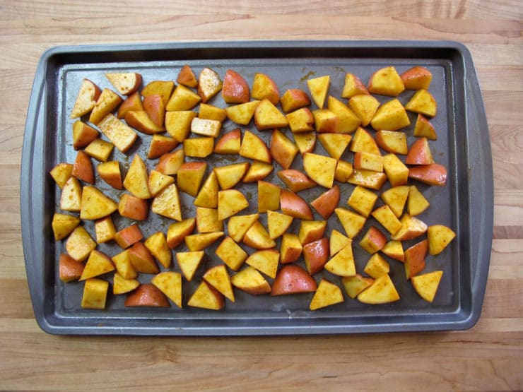 Seasoned potatoes on a baking sheet.