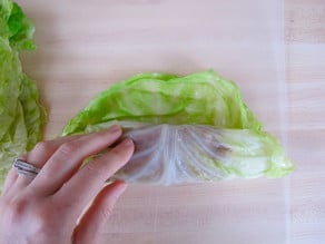 Rolling cabbage leaves around filling.