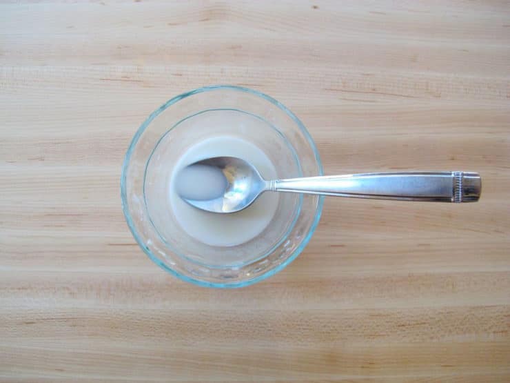 Mixing a cornstarch slurry in a small bowl.