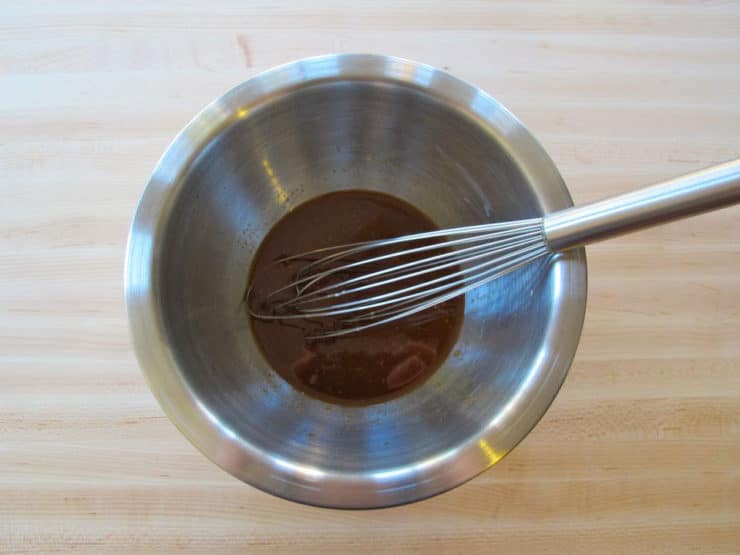 Whisking cornstarch slurry into soy sauce marinade.