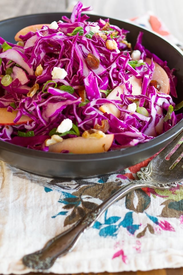 Red Cabbage Apple Salad with Blue Cheese & Walnuts in a bowl next to a fork. 