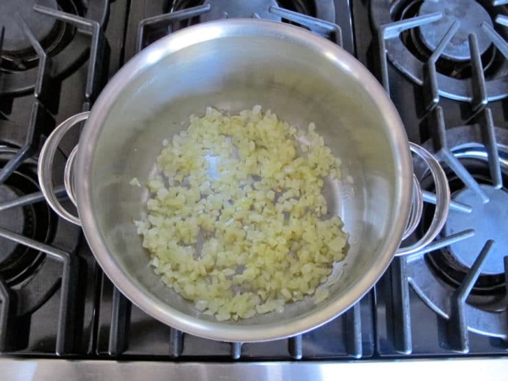 Onion sauteing in a stockpot.