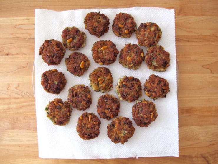 Fried fish cakes draining on paper towel.