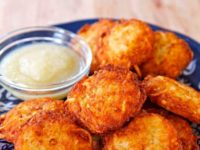 Crispy Panko Potato Latkes on a white plate with a dollop of sour cream