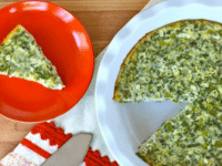 A plate with a crustless quiche featuring spinach, cheese, feta, and asparagus. Pinterest Pin at ToriAvey.com