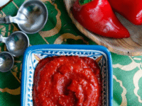 Bowl of Harissa, a spicy Middle Eastern chili garlic sauce served on a fancy small squared shape bowl