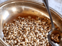 Close-up shot of a dry Black eyed peas on a silver plate with a silver spoon