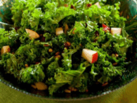 Kale, Pear and Cranberry Salad Pinterest Pin - A green bowl filled with Kale Pear and Cranberry Salad, featuring kale, apples, and a variety of other ingredients.