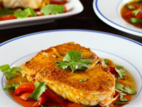 Close-up of Moroccan Paprika Fish dish with peppers and herbs served on a white plate