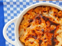 Roasted Butternut Squash Gratin served on a white ceramic pot with handles on top of a blue checkered table clothe