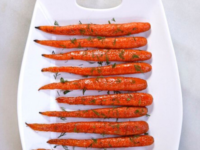 Roasted Carrots with chopped dills lined and served on a white plate tray