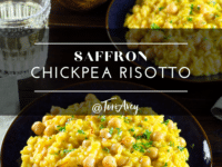 Two bowls of Saffron Chickpea Risotto close-up with a bowl of chopped white vegetable and a glass of water on the side