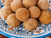 A plate of dates and nuts on wooden table, Sephardic Charoset Truffles Pinterest Pin at ToriAvey.com
