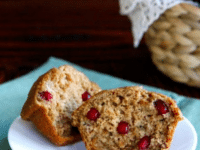A plate with a muffin topped and filled with cranberries