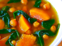 Butternut Squash and Chickpea Soup served on a white bowl with spoon on a table