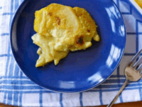 Vegan Saffron Scalloped Potatoes Pinterest Pin - Coconut Saffron Scalloped Potatoes topped with melted cheese served on a blue plate.